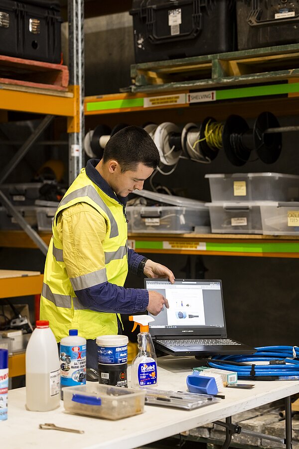 Graduate hydrographic surveyor undertaking equipment training in a workshop environment